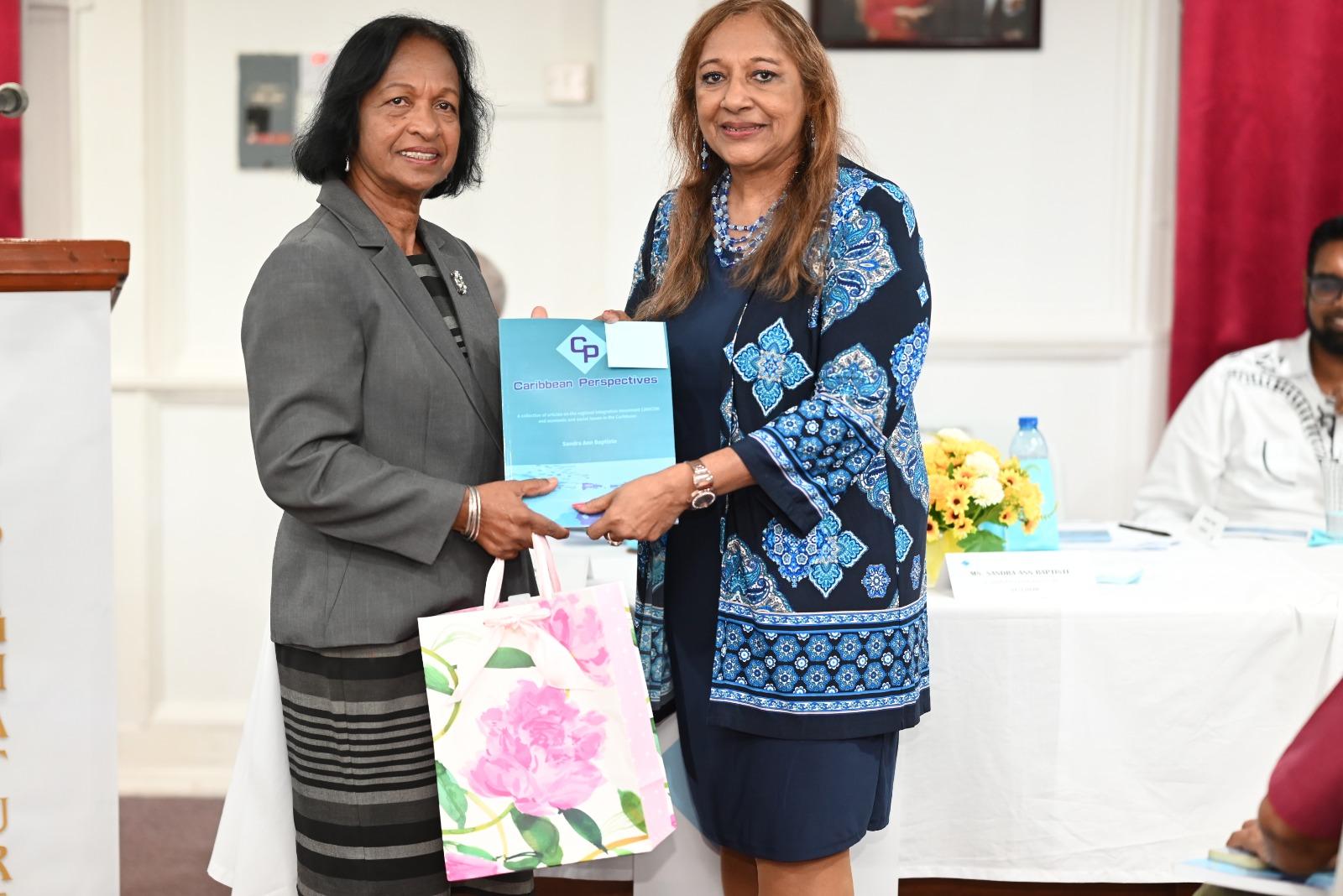 Indra Chandarpal, administrator of the Cheddi Jagan Research Centre, who organised the book launch event, receives a copy of the book and a token of appreciation.